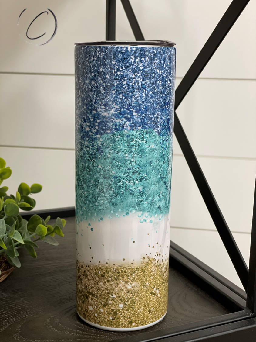 Glitter Ocean 20oz Skinny Tumbler featuring a vibrant ocean-themed design with glitter accents, complete with a reusable straw.
