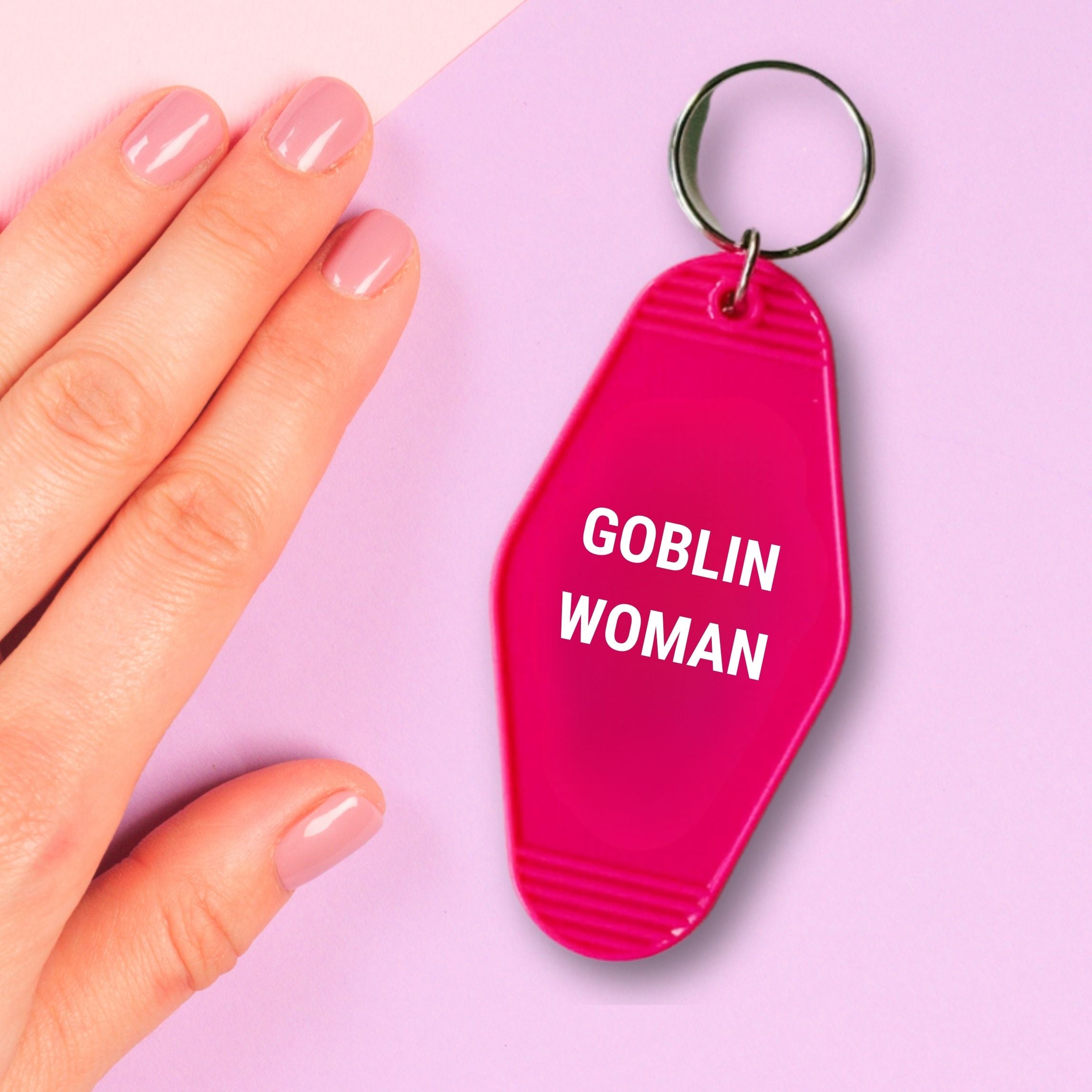 Fuchsia pink Goblin Woman motel style keychain on a split ring, featuring a classic motel design with 'GET BULLISH' text on the back.