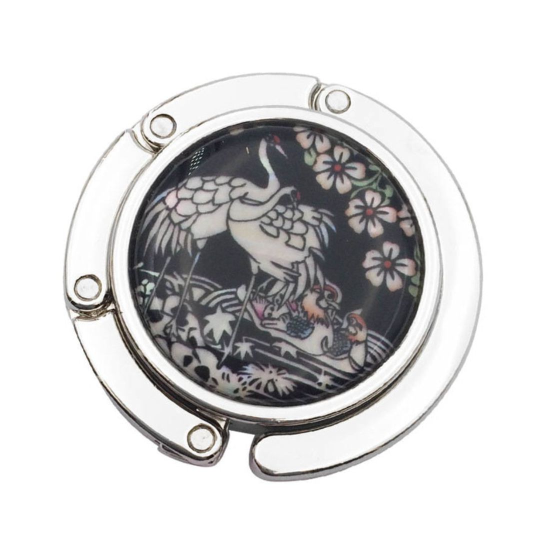 Stylish silver graphic purse hanger with a decorative medallion, designed to keep handbags off the floor.