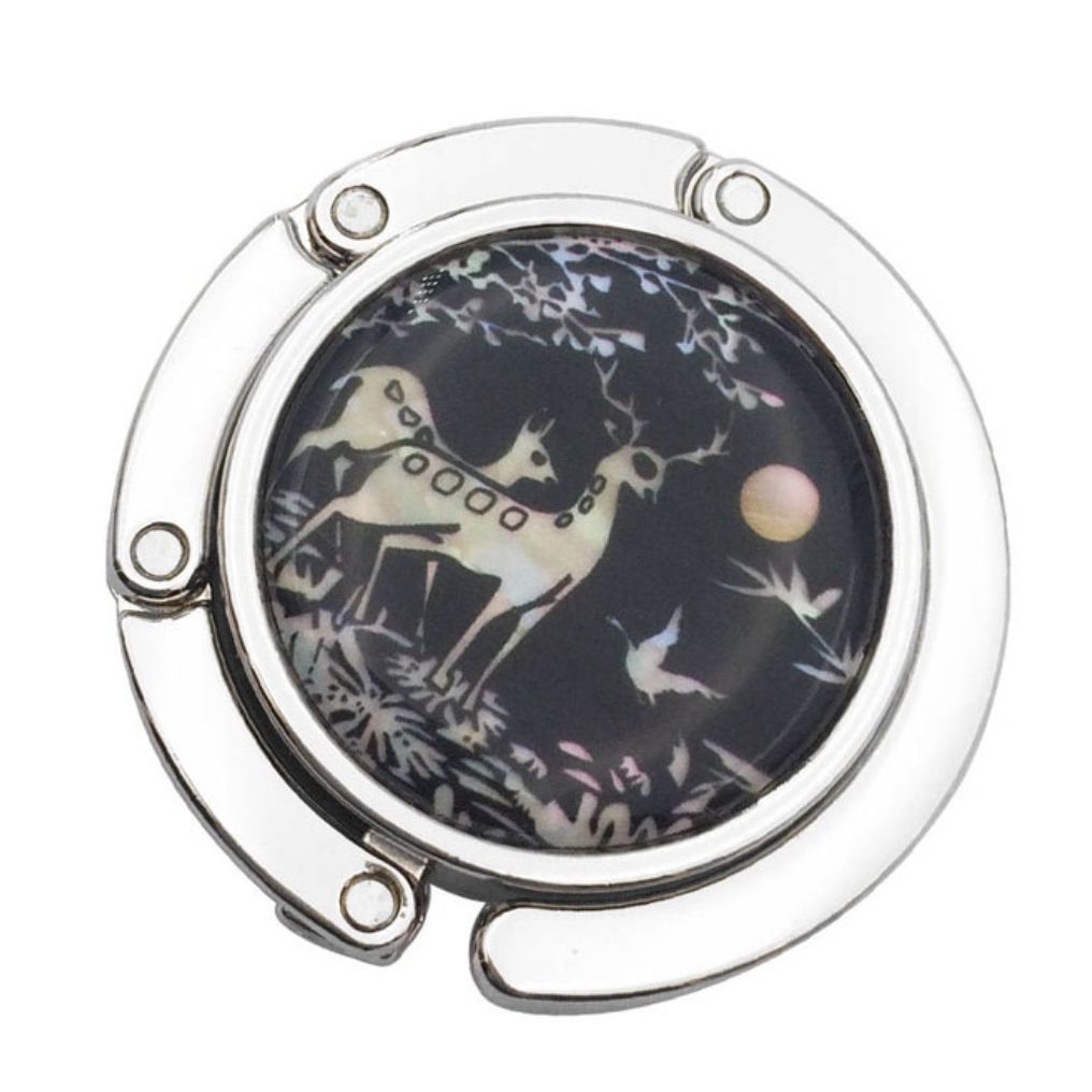 Stylish silver graphic purse hanger with a decorative medallion, designed to keep handbags off the floor.