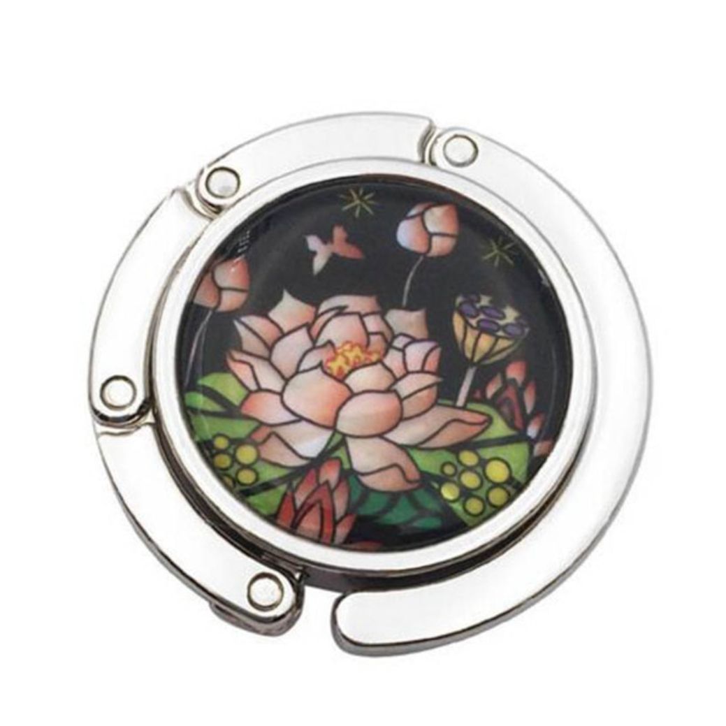 Stylish silver graphic purse hanger with a decorative medallion, designed to keep handbags off the floor.