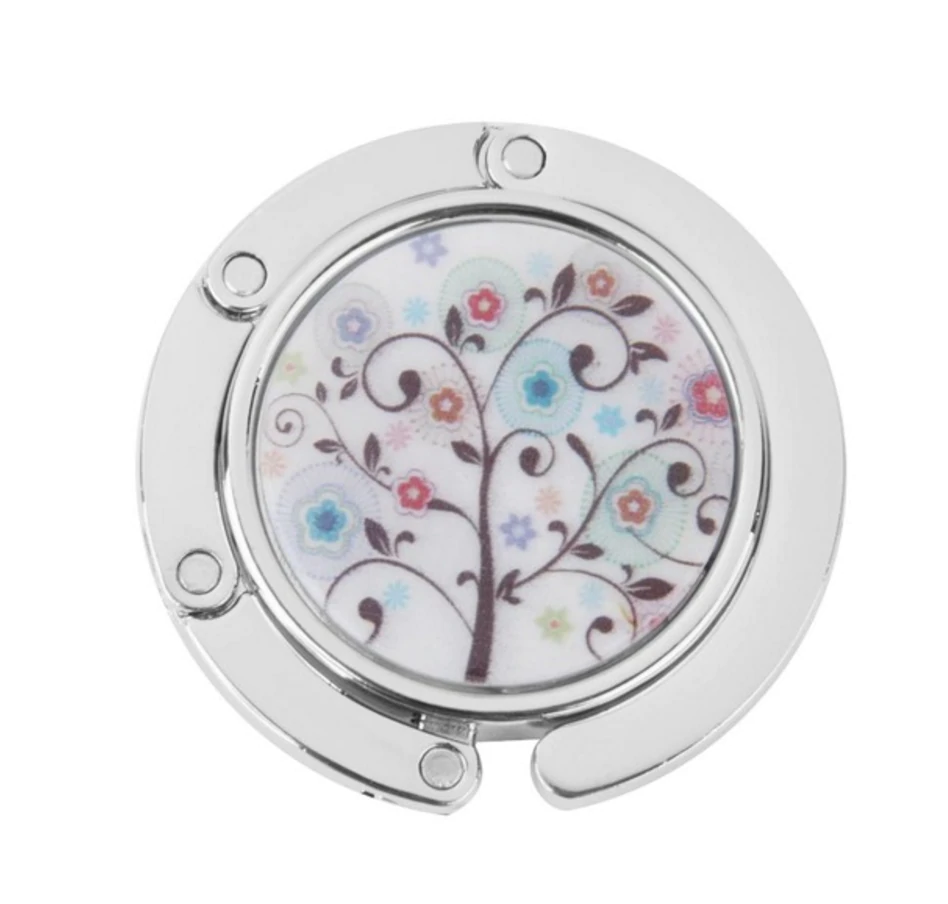 Stylish silver graphic purse hanger with a decorative medallion, designed to keep handbags off the floor.