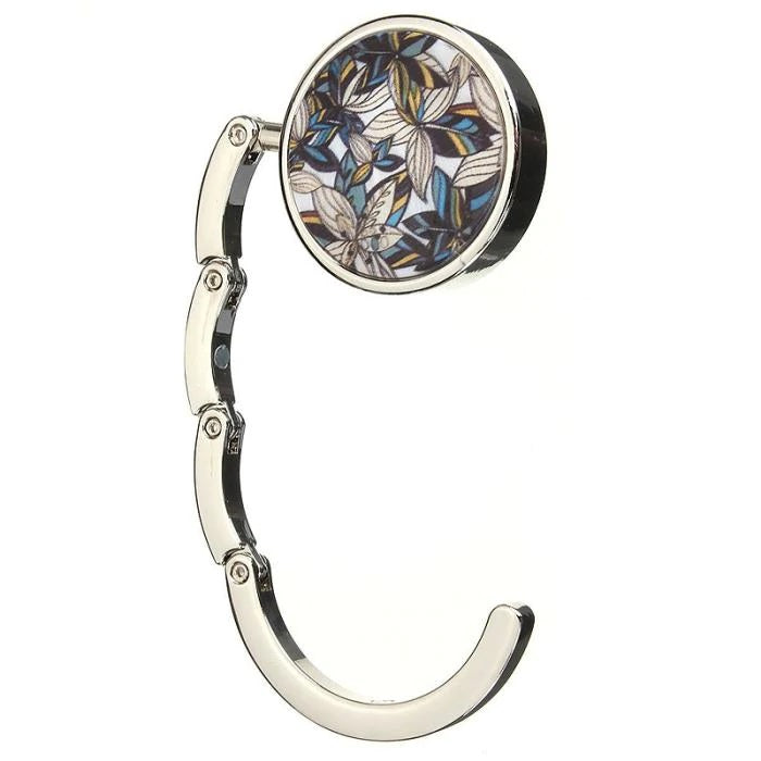 Stylish silver graphic purse hanger with a decorative medallion, designed to keep handbags off the floor.
