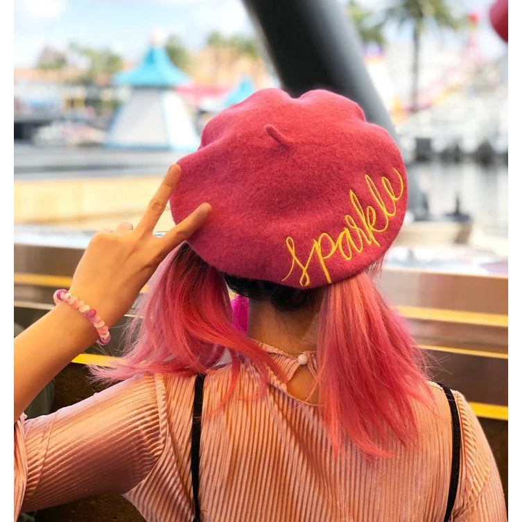 A vibrant yellow beret hat with embroidered 'Hello' text, made from a warm wool and nylon blend, perfect for stylish fall outfits.