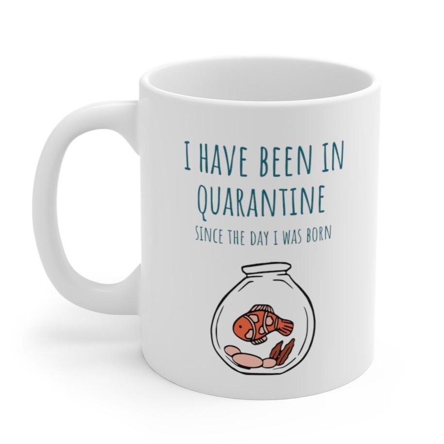 A white ceramic mug with the phrase 'I Have Been in Quarantine Since The Day I Was Born' printed on it, featuring a classic shape and C-handle.