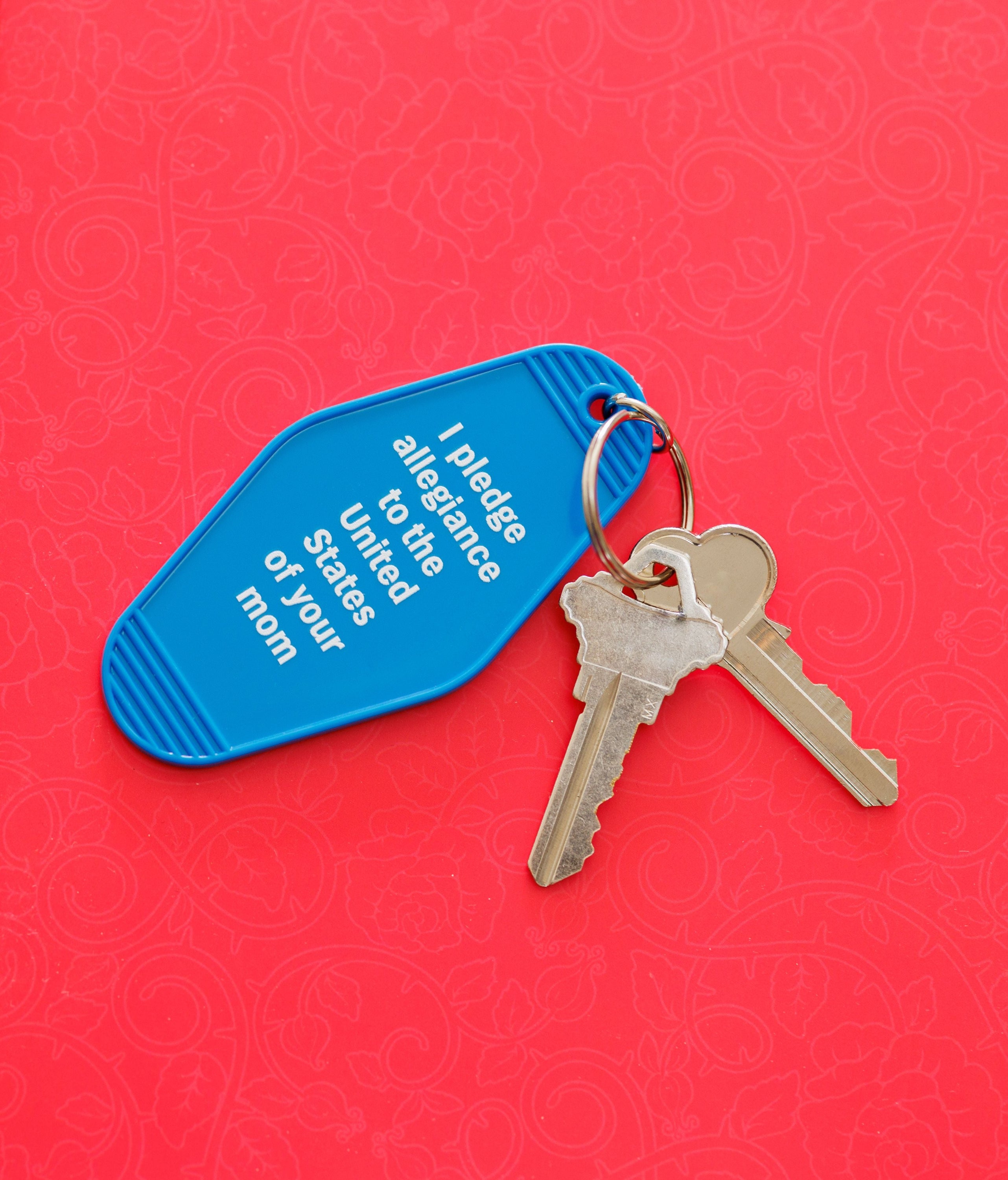 Blue motel keychain with the phrase 'I Pledge Allegiance to the United States of Your Mom' and a split ring attachment.