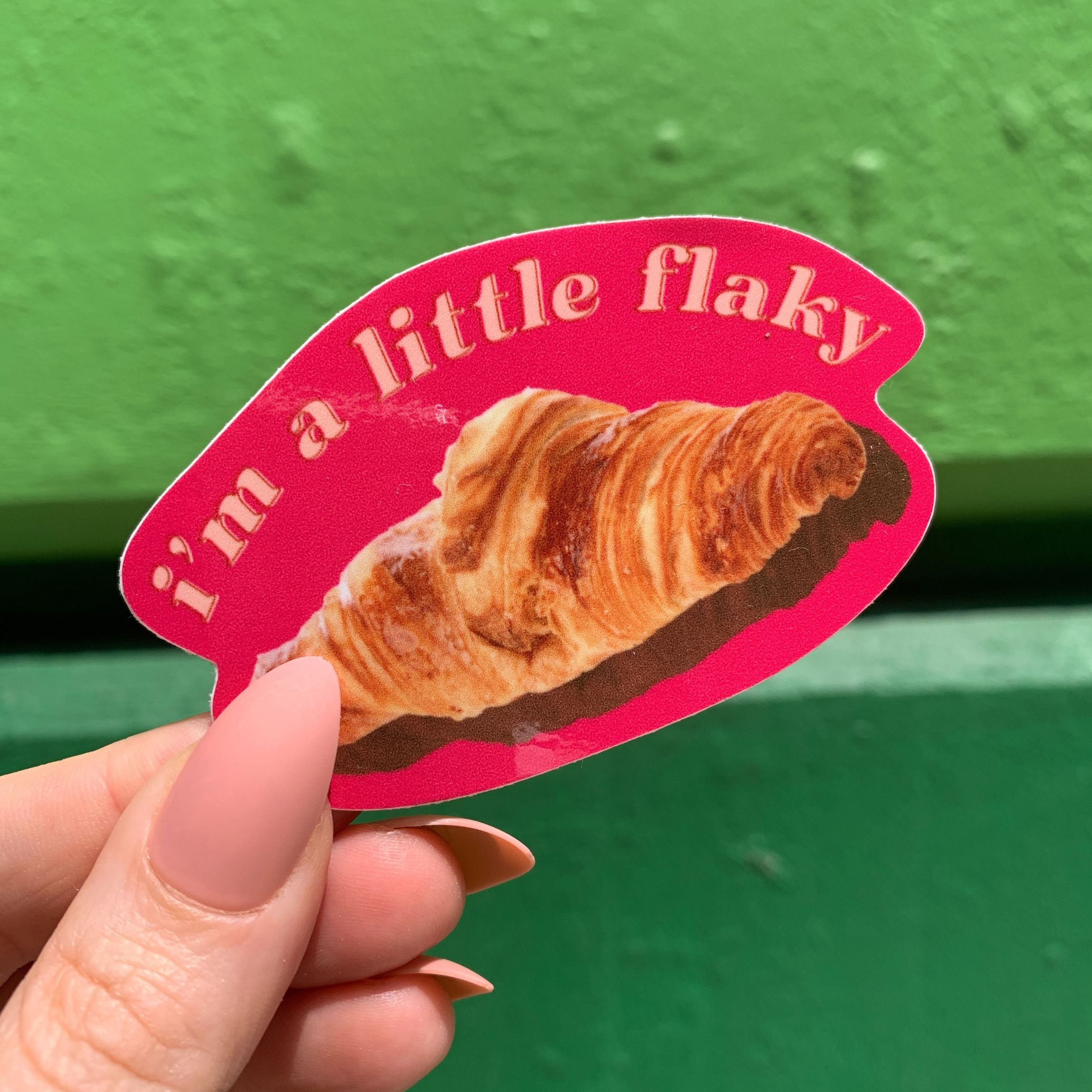 A vinyl die cut decal featuring a croissant with the text 'I’m a Little Flaky', perfect for personalizing items.