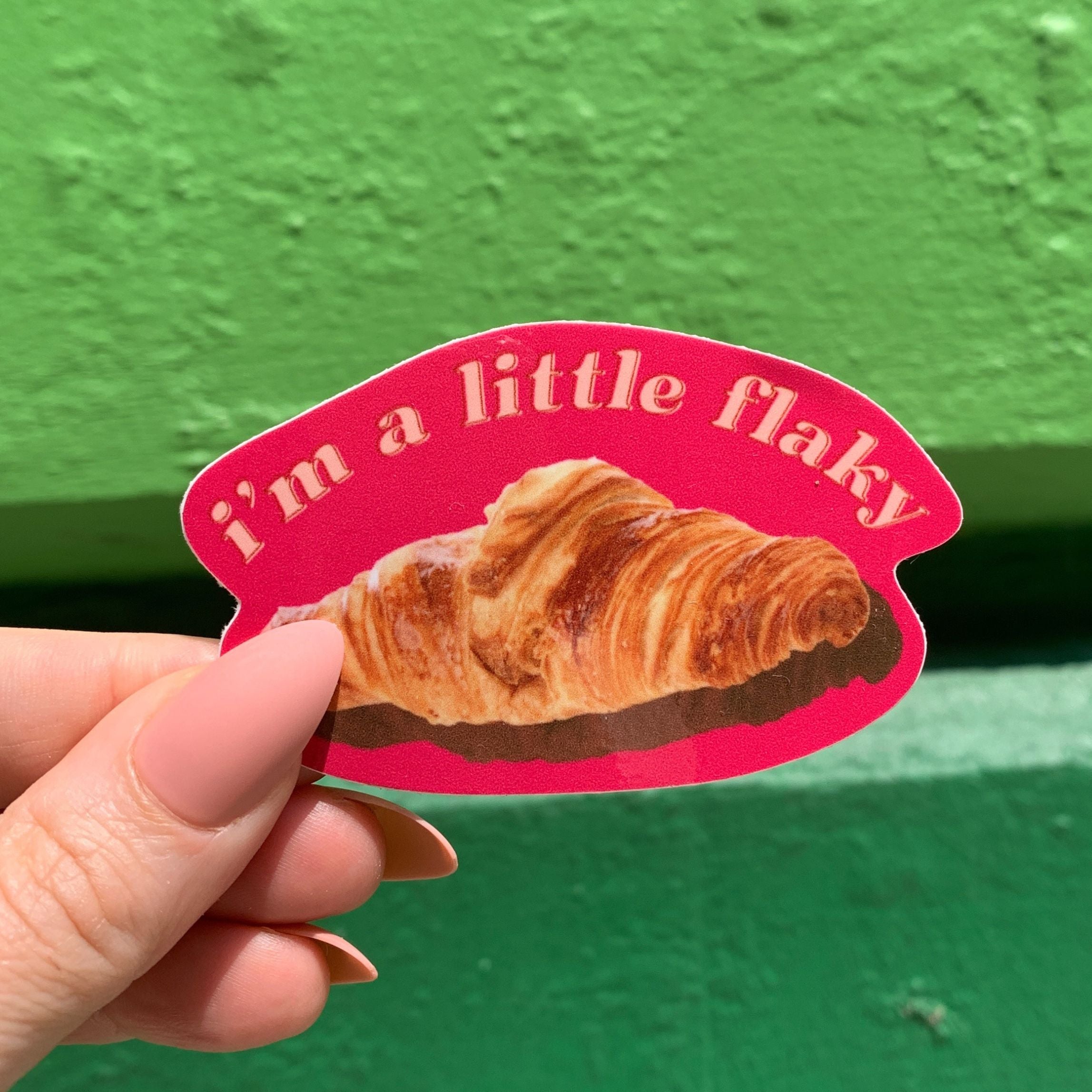 A vinyl die cut decal featuring a croissant with the text 'I’m a Little Flaky', perfect for personalizing items.