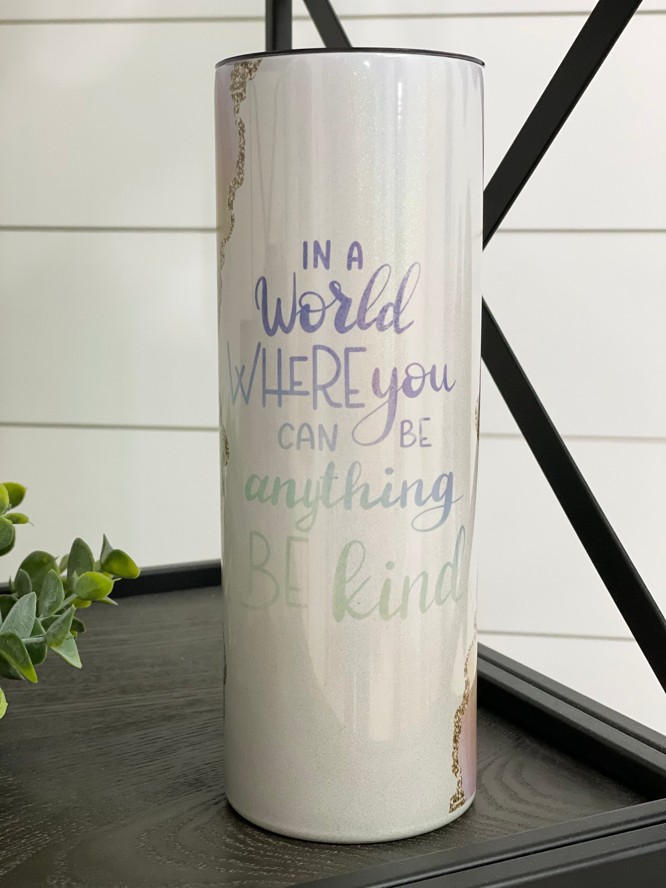 In A World... Be Kind 20oz Shimmer Skinny Tumbler with a rainbow shimmer effect and reusable straw.