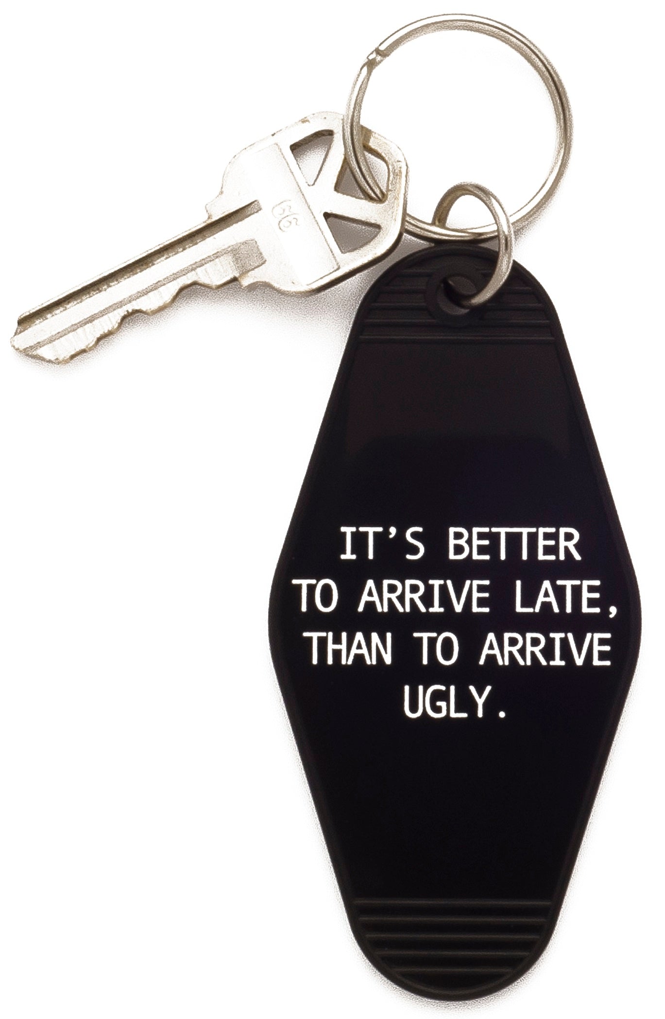 Black keychain with the phrase 'It's Better To Arrive Late, Than To Arrive Ugly' in a stylish hotel tag design.