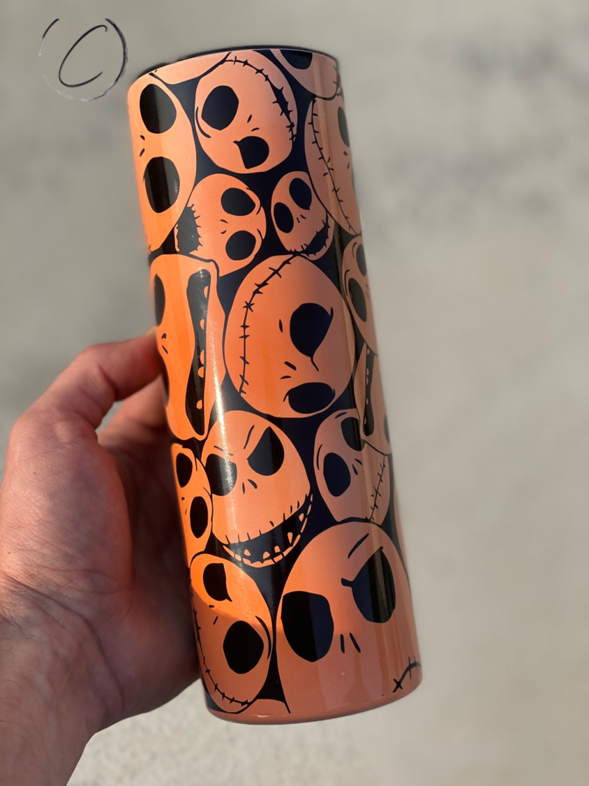 Jack Skellington 20oz UV Orange Skinny Tumbler with vibrant color-changing design in sunlight, featuring a reusable straw.