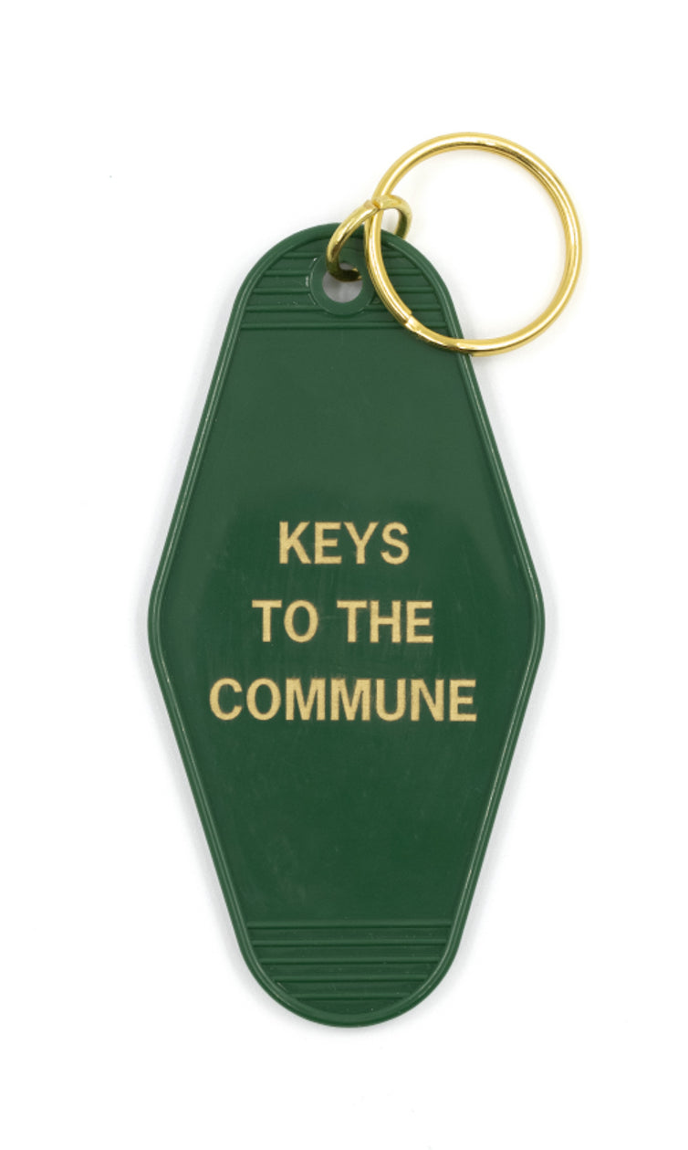 Green and gold motel-style keychain with 'KEYS TO THE COMMUNE' text, attached to a split ring.