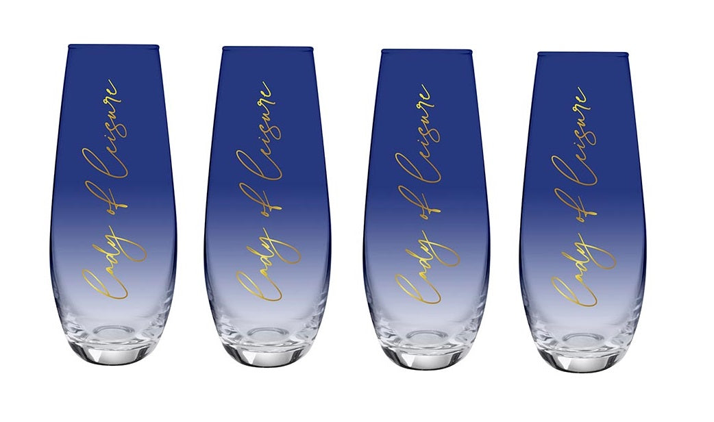Set of four dark blue tinted stemless flute champagne glasses with gold lettering 'Lady of Leisure'.