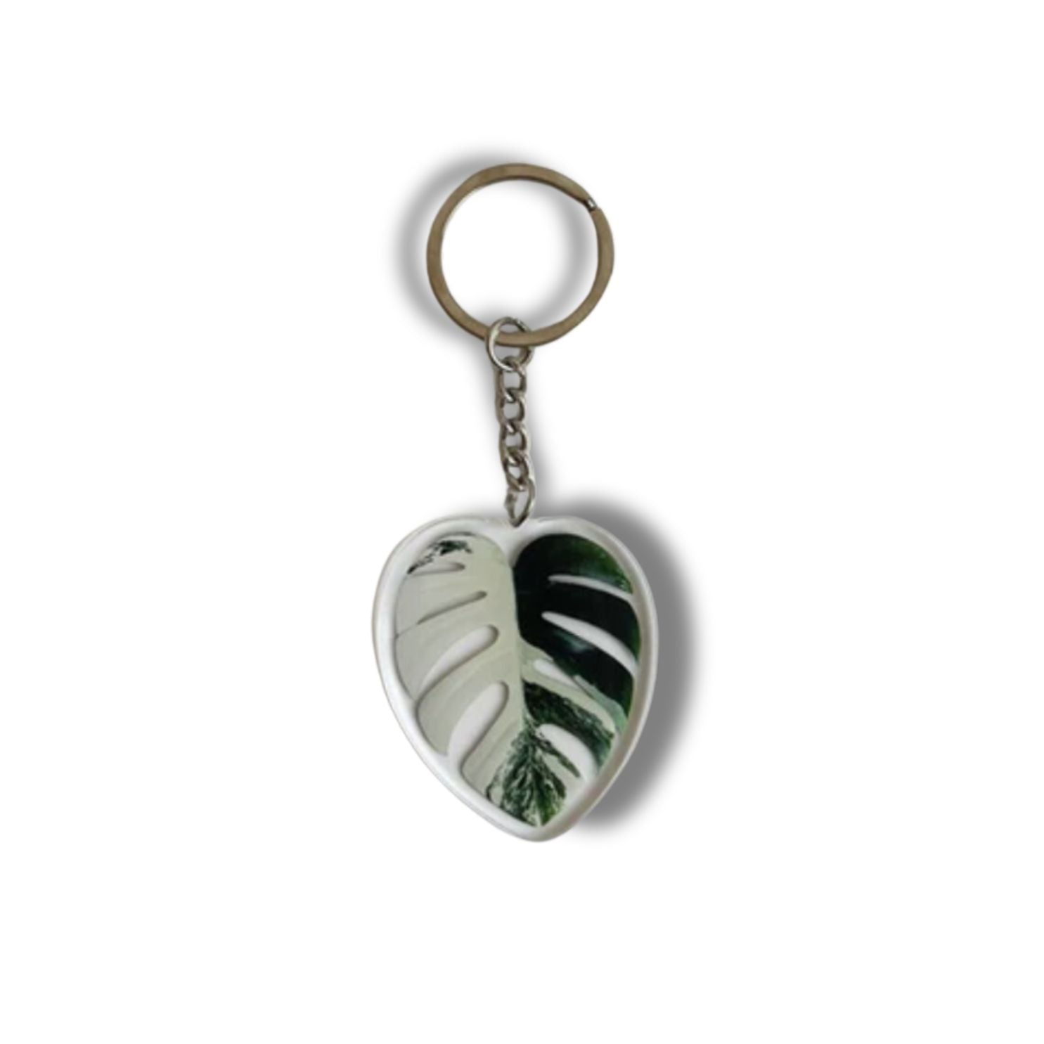 A collection of seven illustrated leaf acrylic keychains displayed on a clear background, showcasing vibrant colors and double-sided designs.