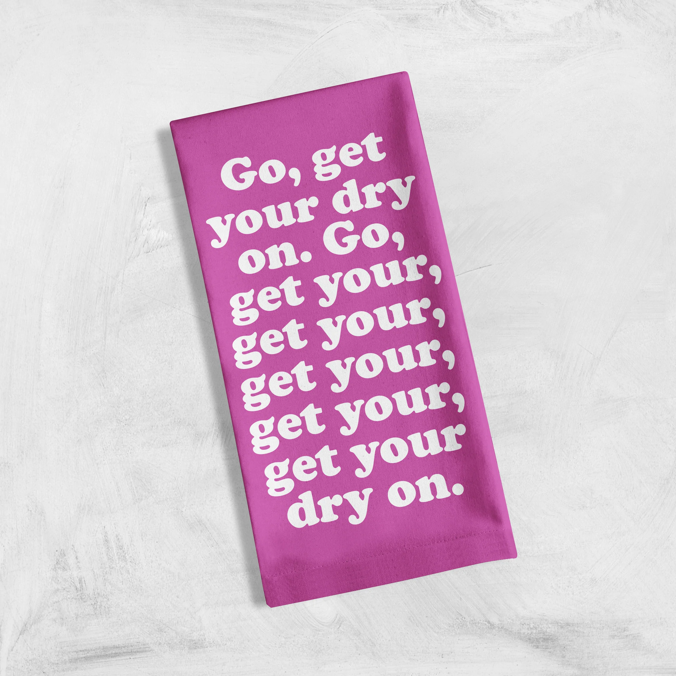 Missy Elliott-inspired cotton tea towel with the phrase 'Go, get your dry on' screen-printed in vibrant colors, hanging on a kitchen rack.