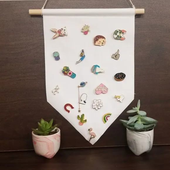 A colorful assortment of 20 mystery enamel pins displayed on a sturdy hanging banner, showcasing various designs and brands.