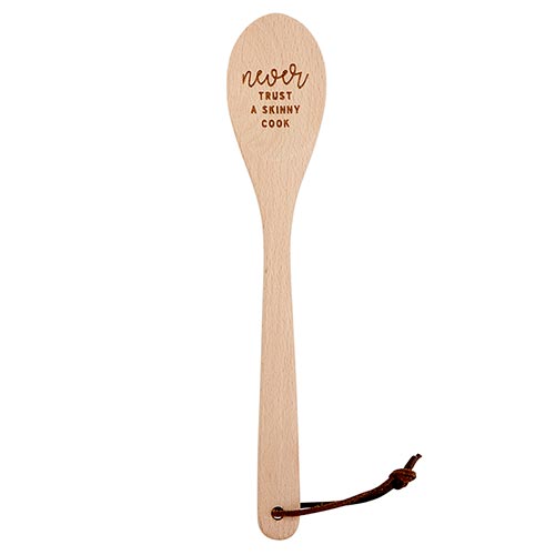 A wooden cooking spoon with the phrase 'Never Trust A Skinny Cook' engraved, placed in a stylish canvas gift bag.