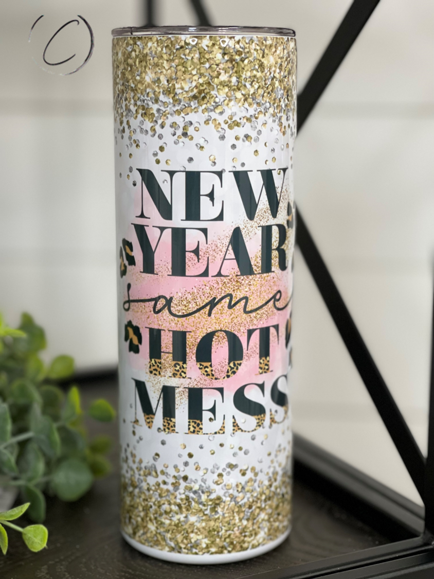 A stylish 20oz skinny tumbler featuring the phrase 'New Year Same Hot Mess' with a vibrant full wrap design, perfect for hot and cold beverages.