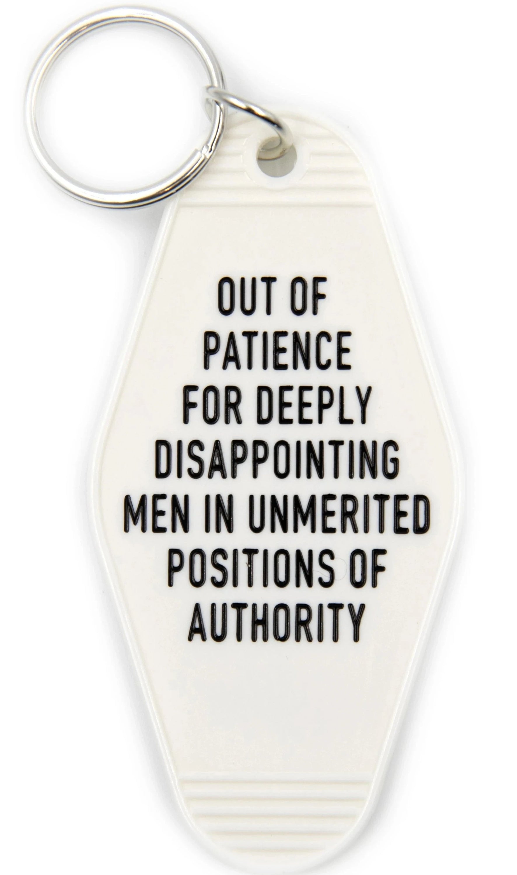 White motel-style keychain with black lettering stating 'OUT OF PATIENCE FOR DEEPLY DISAPPOINTING MEN IN UNMERITED POSITIONS OF AUTHORITY'.