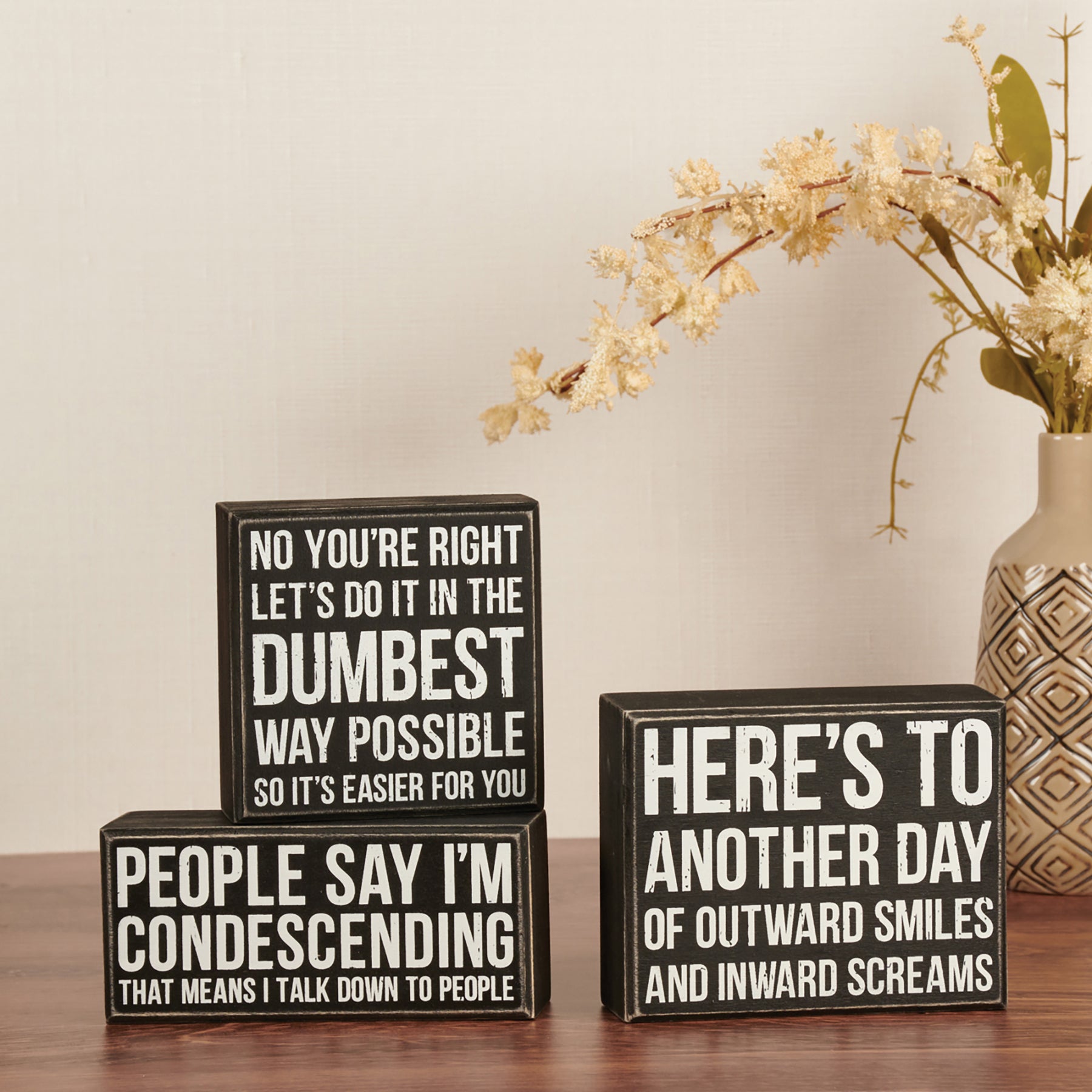 Outward Smiles Inward Screams Box Sign in black and white, featuring humorous text and distressed wooden details.
