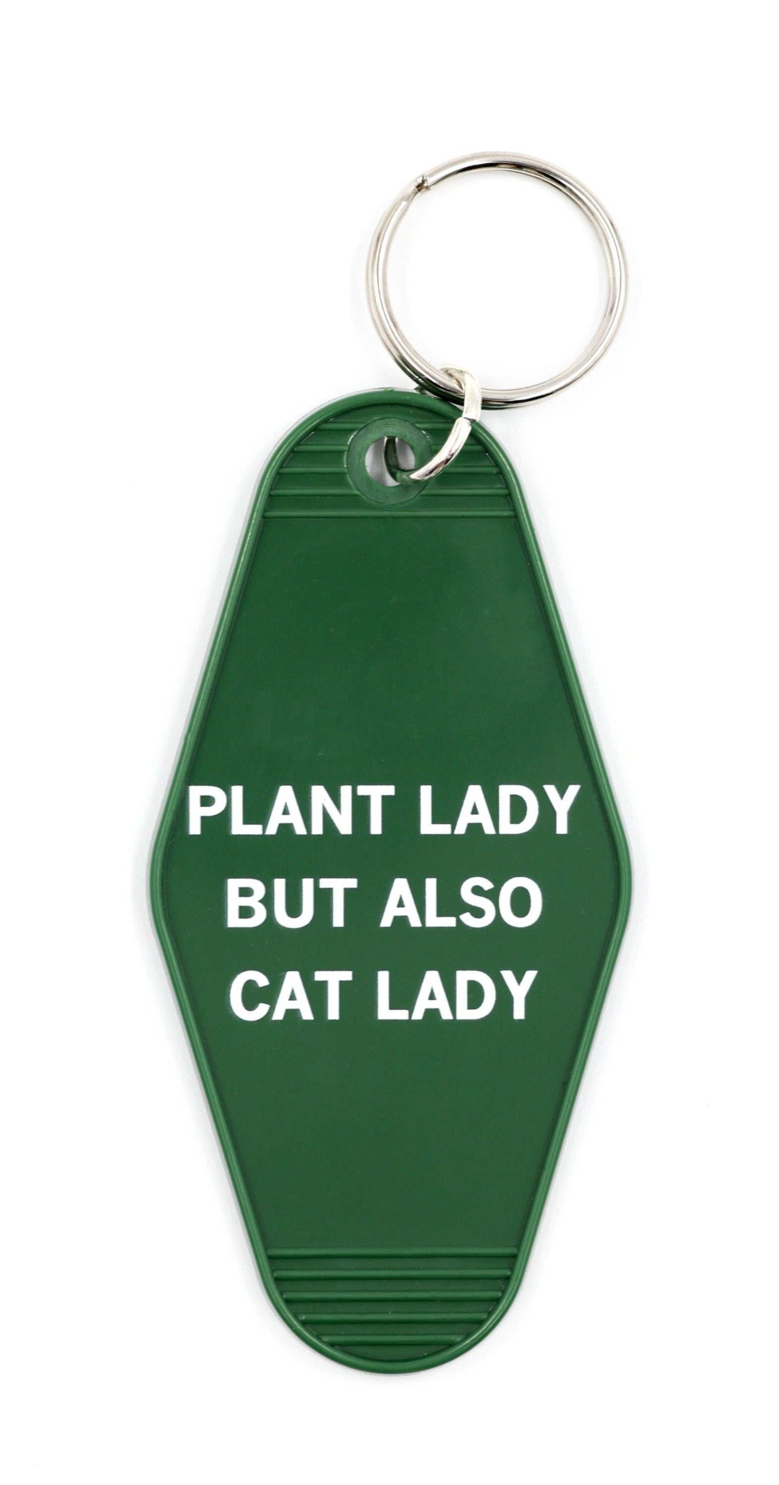 Green motel-style keychain with white lettering reading 'PLANT LADY BUT ALSO CAT LADY', featuring a split ring attachment.