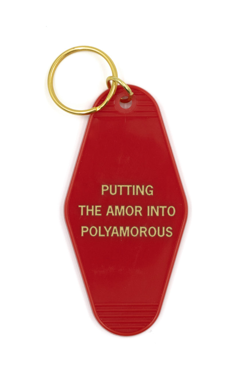 Red and gold polyamorous motel style keychain with gold lettering reading 'PUTTING THE AMOR IN POLYAMOROUS', attached to a split ring.