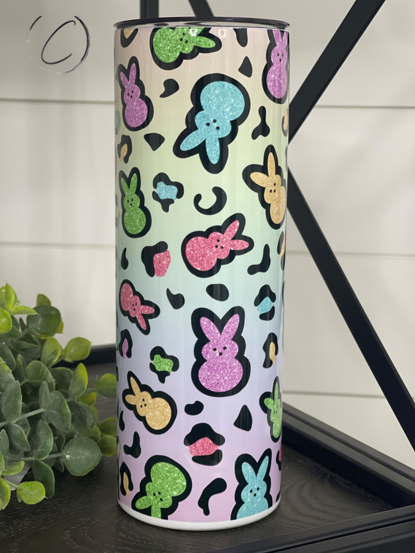 A colorful 20oz skinny tumbler featuring a vibrant rainbow leopard design, complete with a reusable straw.