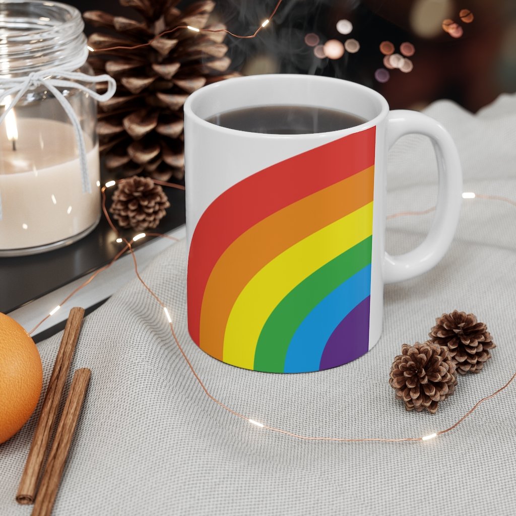 A colorful Rainbow Love Mug made of white ceramic, featuring a C-handle and rounded corners, perfect for coffee, tea, or hot chocolate.