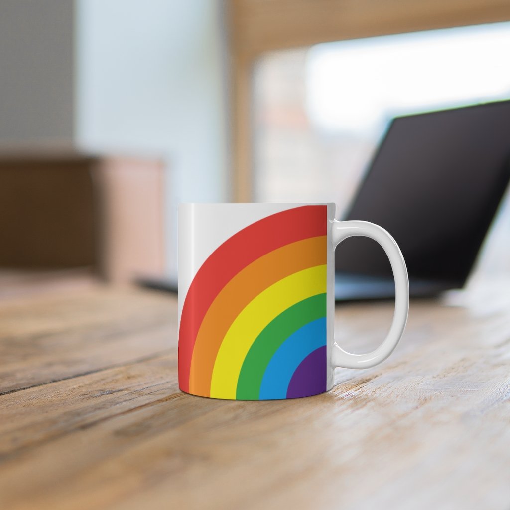 A colorful Rainbow Love Mug made of white ceramic, featuring a C-handle and rounded corners, perfect for coffee, tea, or hot chocolate.
