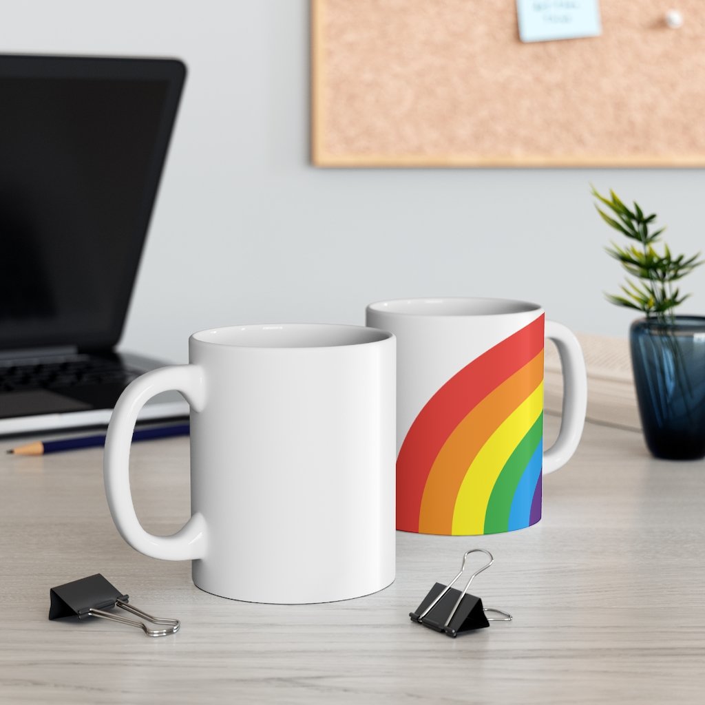 A colorful Rainbow Love Mug made of white ceramic, featuring a C-handle and rounded corners, perfect for coffee, tea, or hot chocolate.