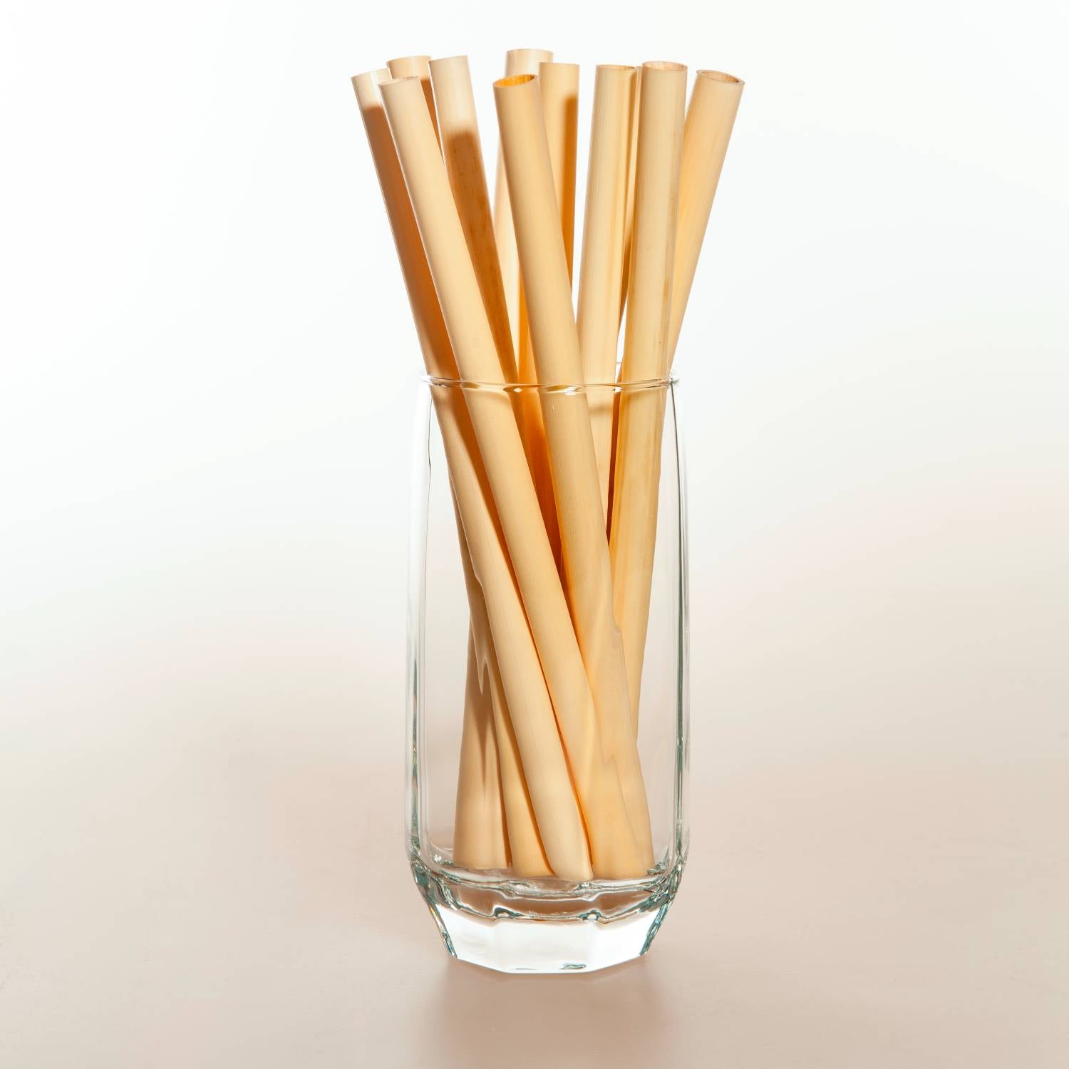 A bundle of large reed straws, showcasing their natural beige color and eco-friendly design, ideal for smoothies and beverages.
