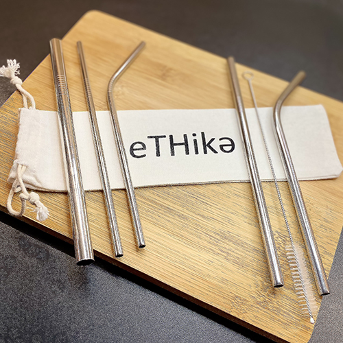 Set of reusable stainless steel straws in a mini cotton pouch with a cleaning brush.