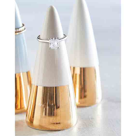 Ceramic ring cone holder in pale grey with a gold metallic bottom, elegantly displaying rings.