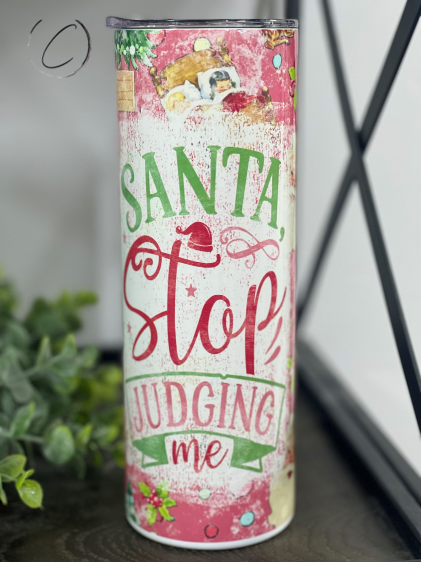 Santa Stop Judging Me 20oz Skinny Tumbler with festive design and reusable straw.