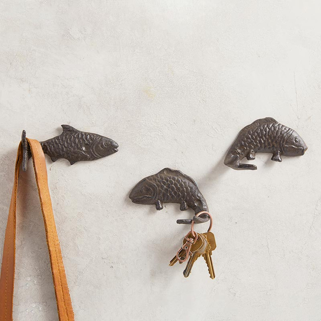 Set of 3 decorative fish-shaped cast iron wall hooks, perfect for coastal decor, showcasing a whimsical design.