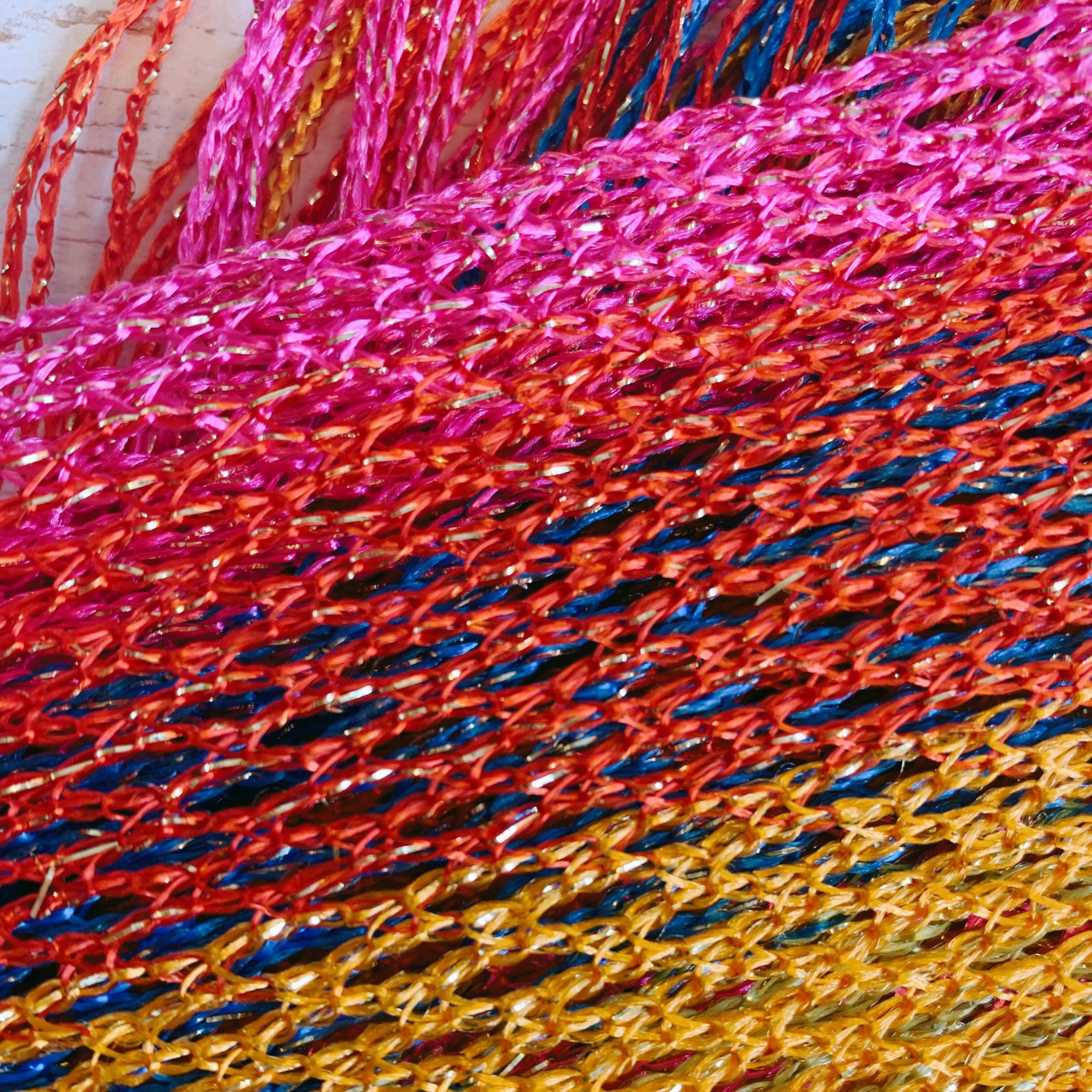 A vibrant Shimmer Mesh Pride Scarf Wrap in Rainbow Stripe, showcasing colorful stripes and a lightweight, shimmering mesh fabric, perfect for summer events.