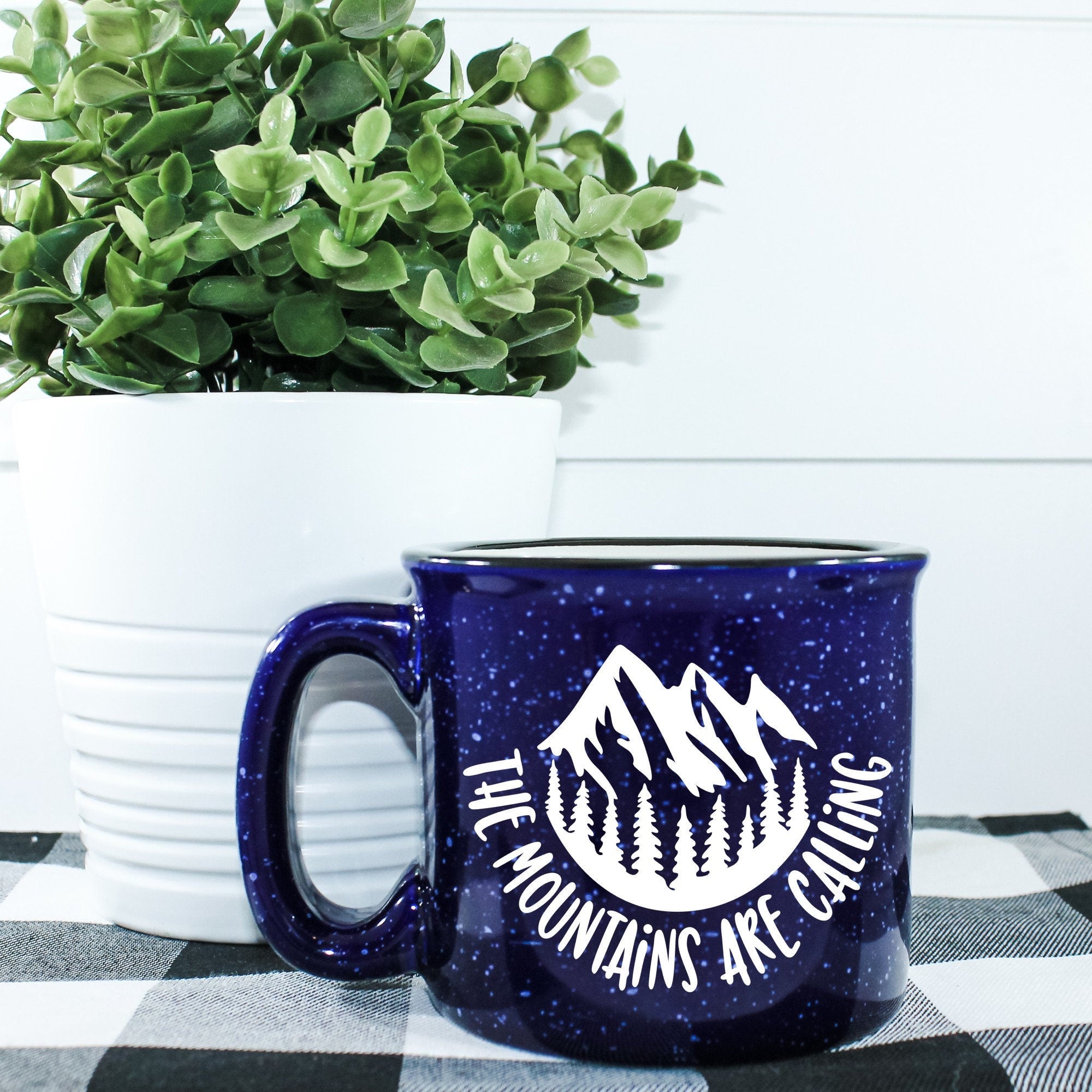 Ceramic campfire mug with 'The Mountains Are Calling And I Must Go' design, perfect for outdoor enthusiasts.