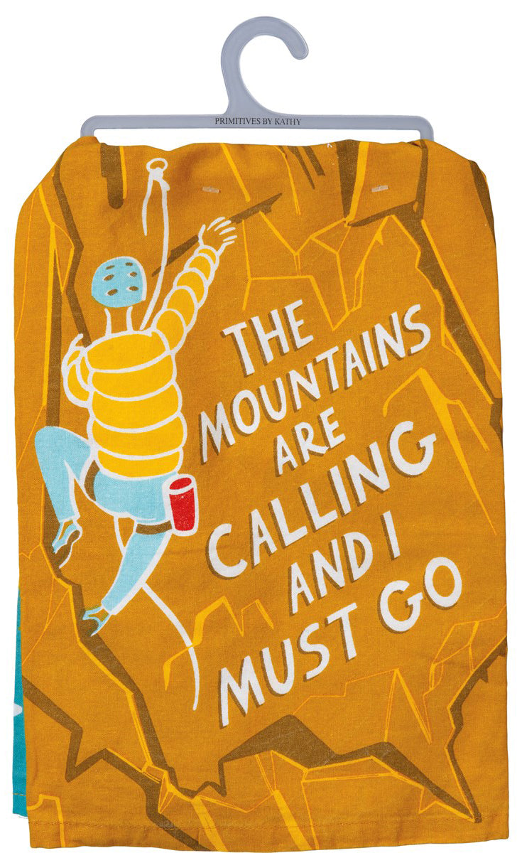 A colorful cotton dish towel featuring mountain designs and the phrase 'The Mountains Are Calling And I Must Go'.