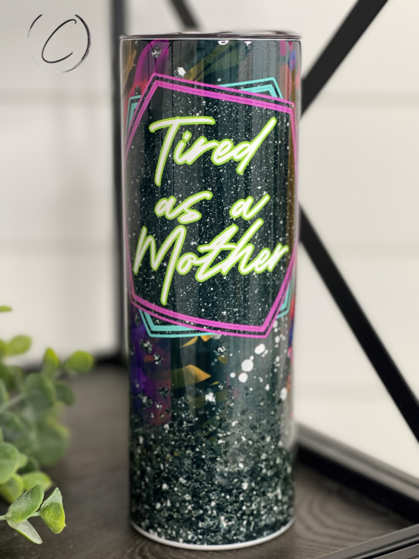 Tired As A Mother Splatter 20oz Skinny Tumbler with vibrant splatter design and reusable straw.