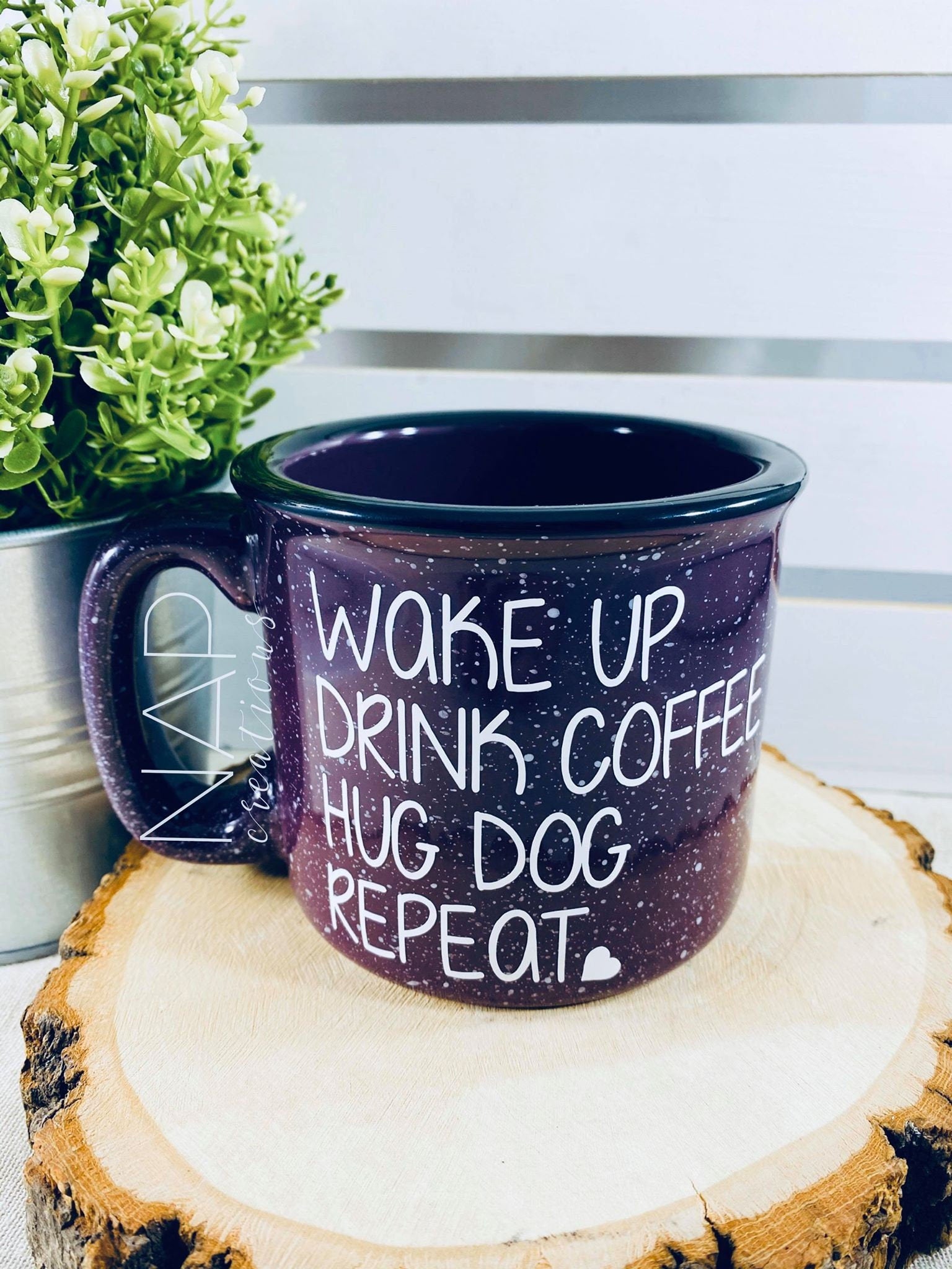 Ceramic campfire mug with the phrase 'Wake Up Drink Coffee Hug Dog Repeat' printed on one side, perfect for dog lovers.