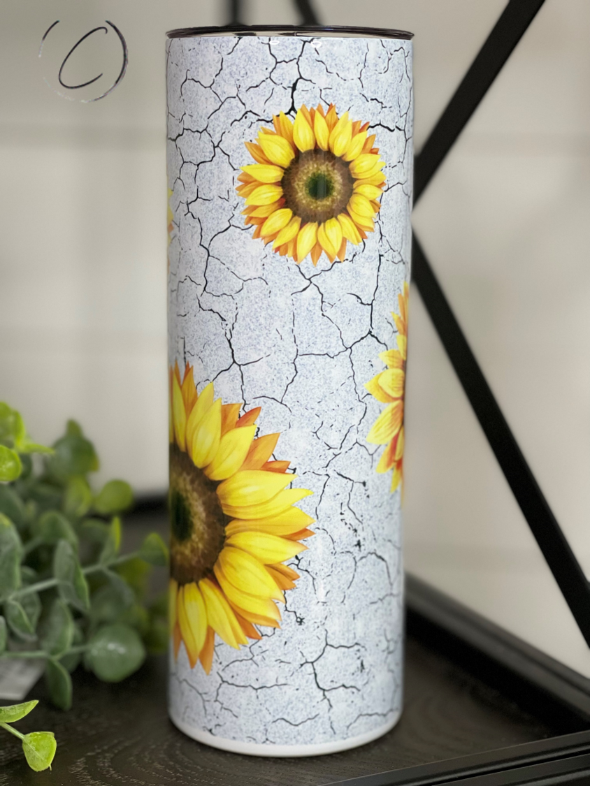 A 20oz skinny tumbler featuring a vibrant watercolor sunflower design, perfect for hot and cold beverages.