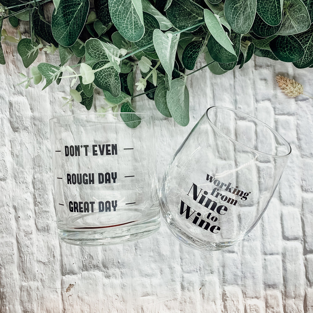 A set of elegant stemless wine and whiskey glasses with witty quotes, beautifully packaged in a decorative gift box.