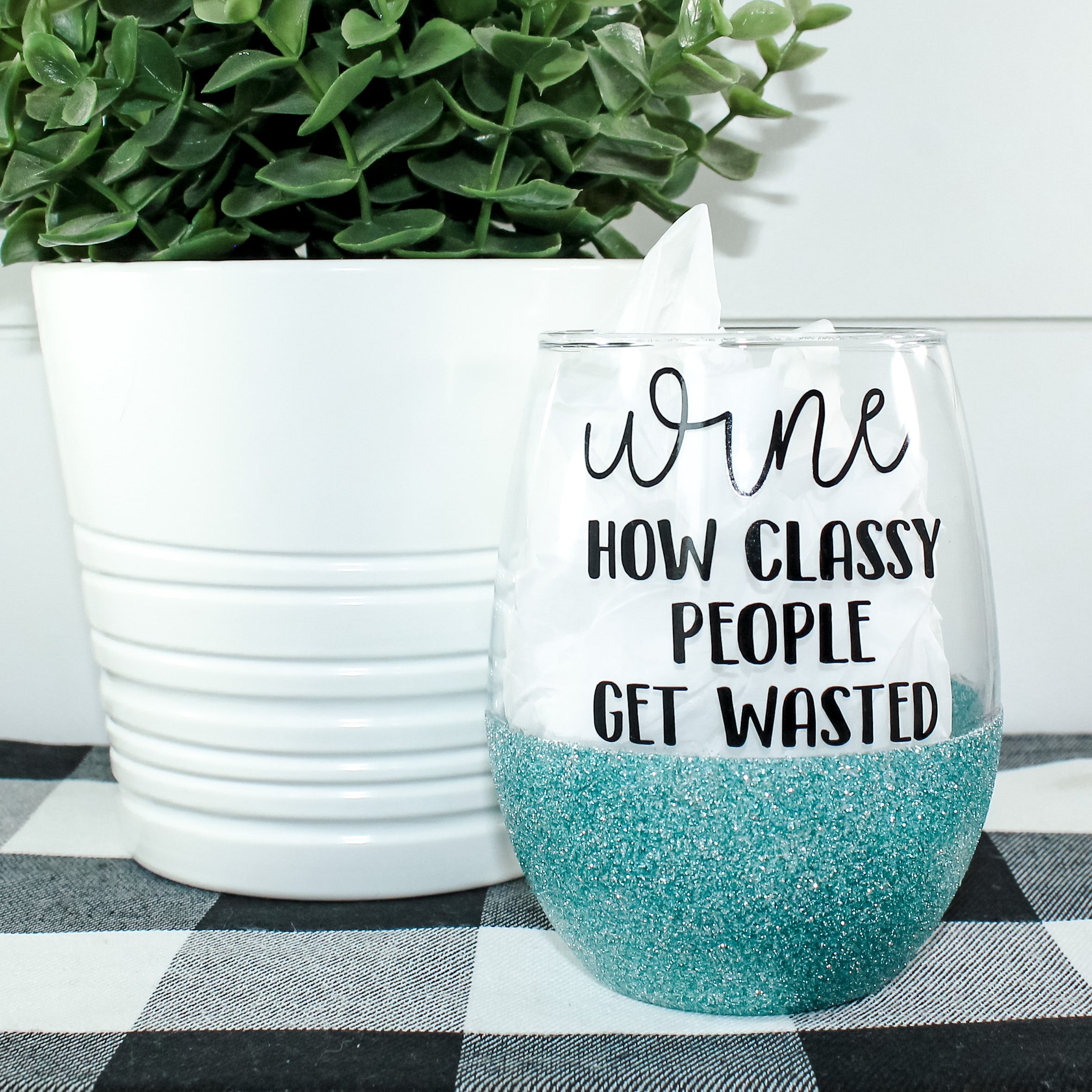 A stylish stemless wine glass adorned with vibrant glitter, showcasing a unique design on one side.