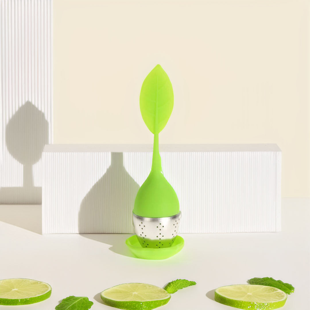 Boule à thé en silicone colorée avec un design moderne, remplie de thé en vrac, posée sur un support.