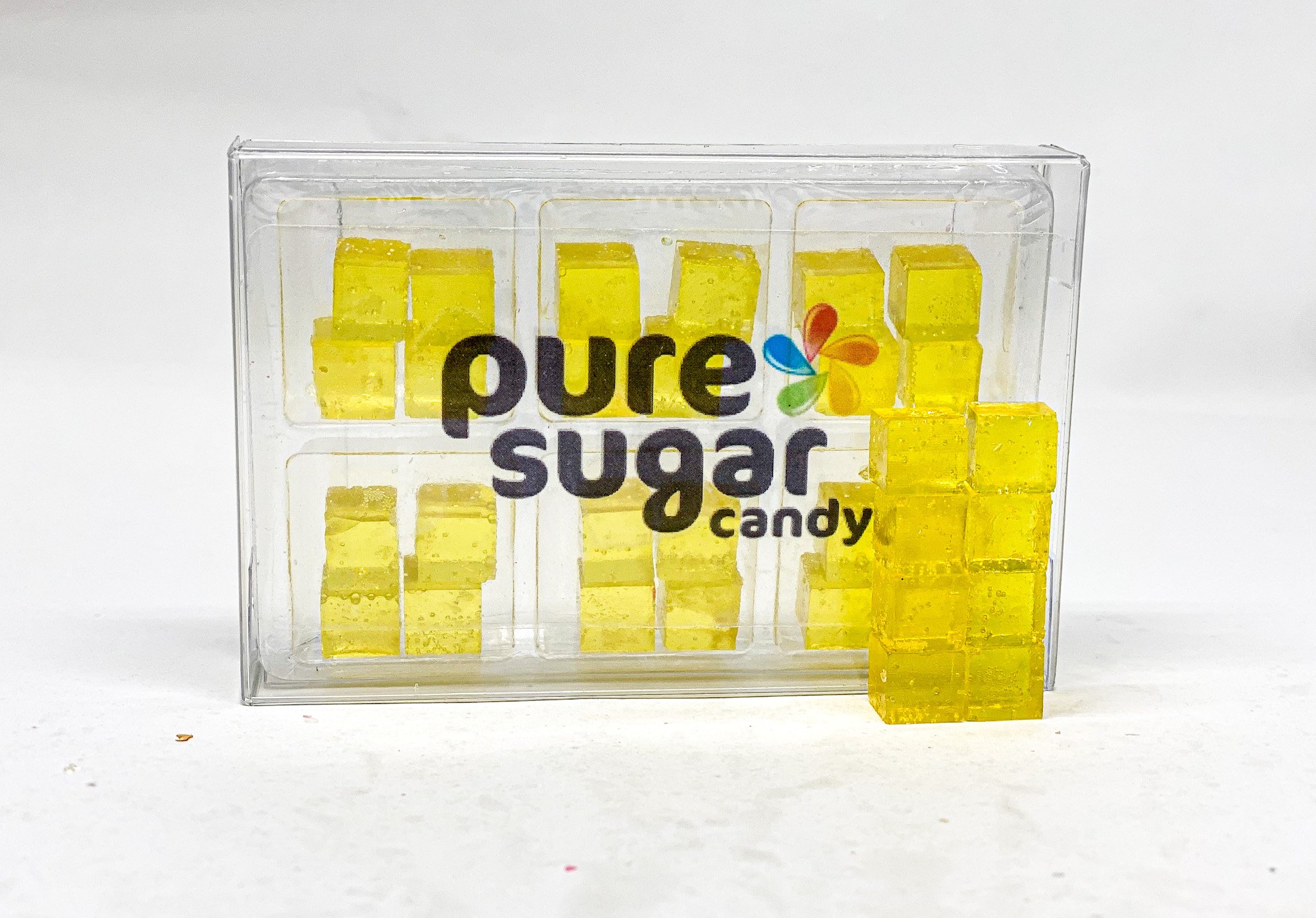 A colorful tray of Candy Cubes in pineapple banana flavor, showcasing their vibrant yellow and orange colors.