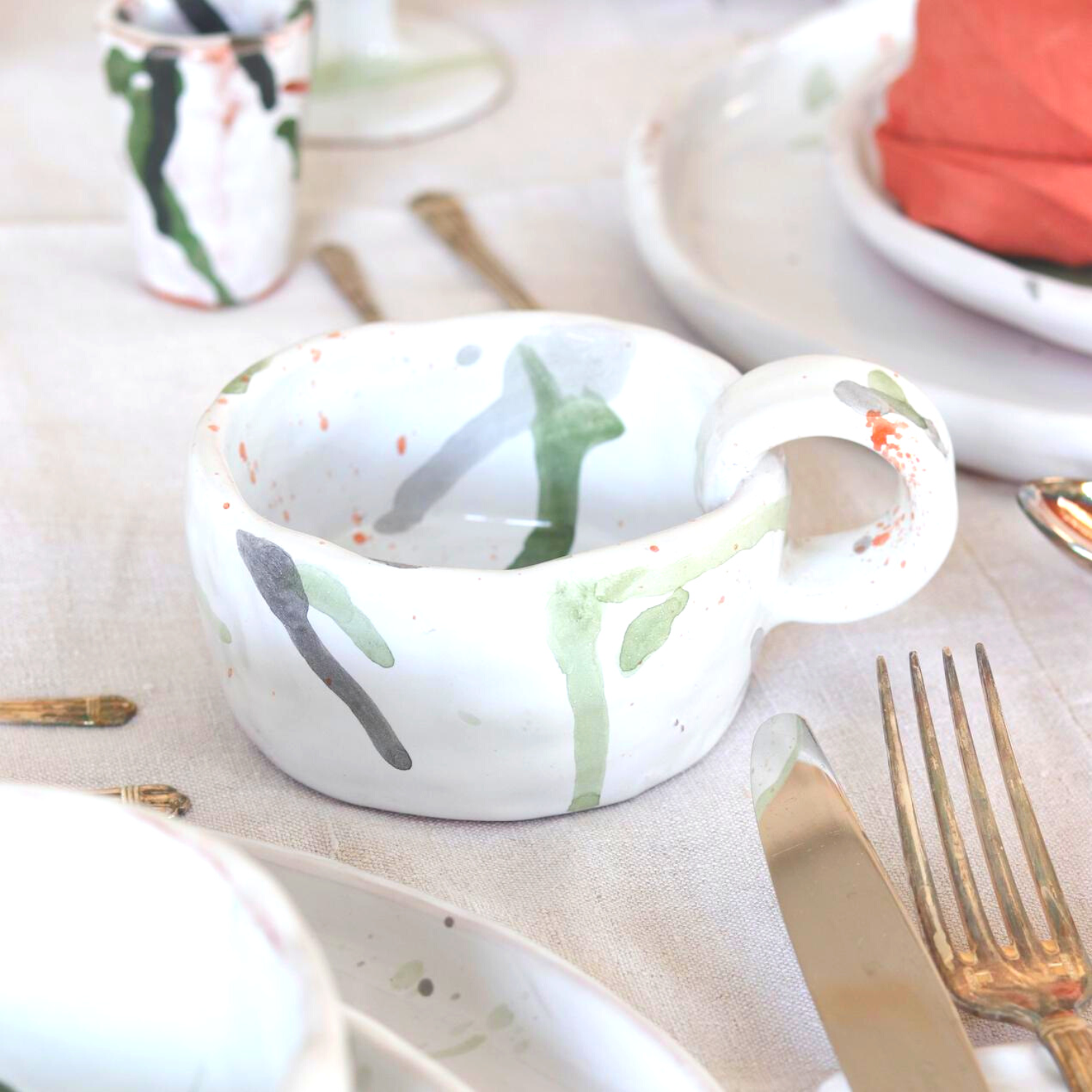 Ceramic Handmade Mug featuring a unique watercolour design in shades of green, grey, blue, and orange, showcasing artisanal craftsmanship.