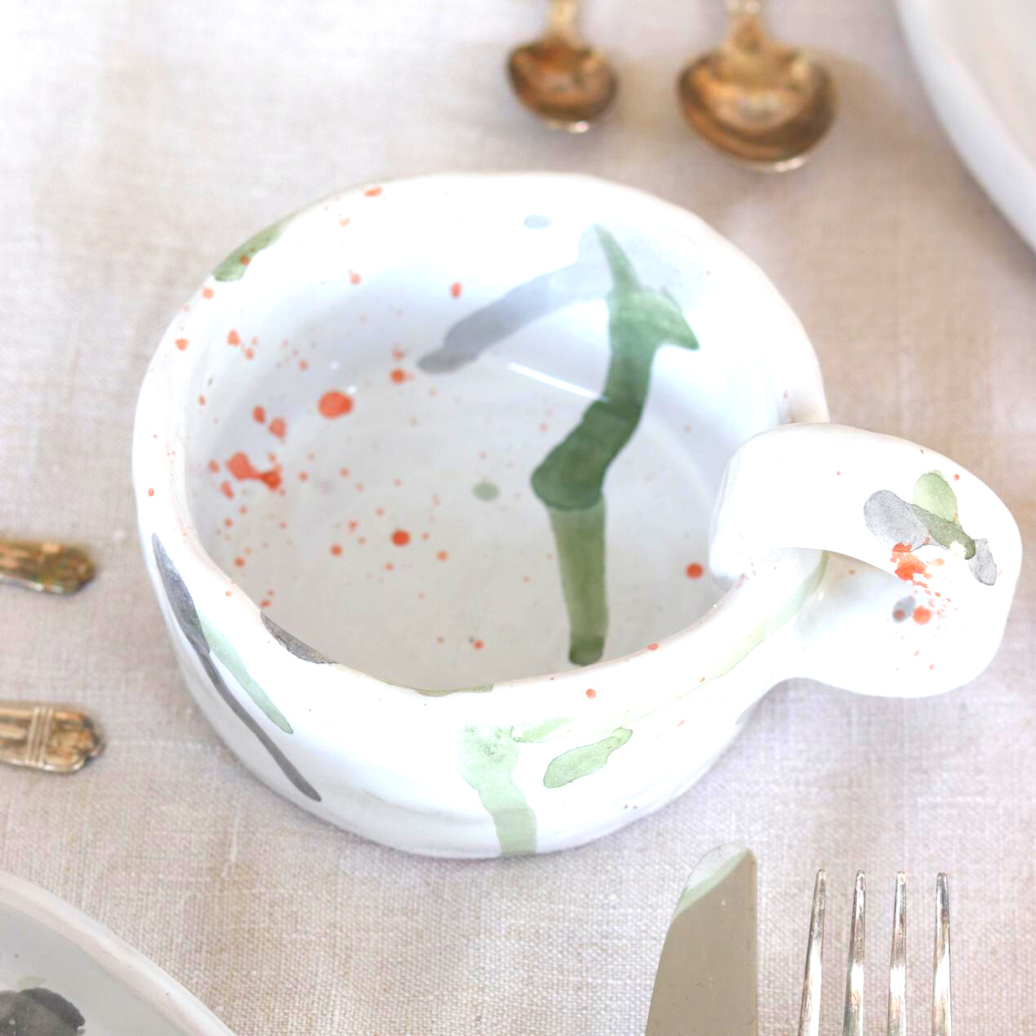 Ceramic Handmade Mug featuring a unique watercolour design in shades of green, grey, blue, and orange, showcasing artisanal craftsmanship.