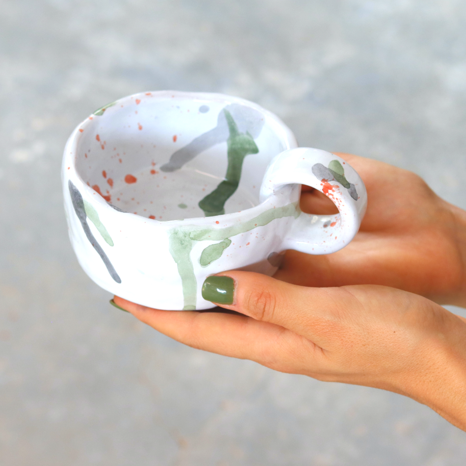 Ceramic Handmade Mug featuring a unique watercolour design in shades of green, grey, blue, and orange, showcasing artisanal craftsmanship.
