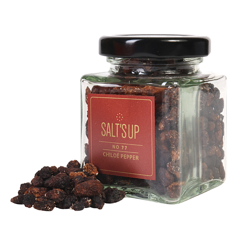 Chiloé pepper in a glass jar, showcasing its unique colors and shape resembling small raisins.