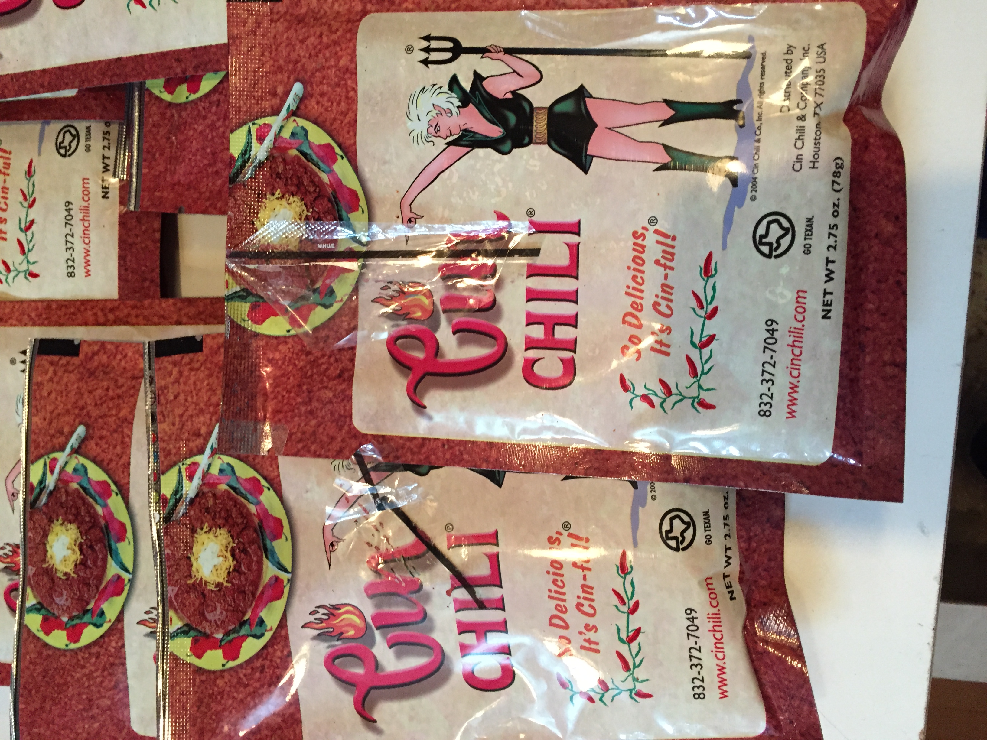 A 12 pack of CIN CHILI packages, showcasing the vibrant packaging and branding, perfect for chili lovers.